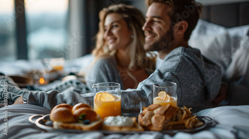Couple enjoying a gourmet breakfast in bed at a luxurious hotel