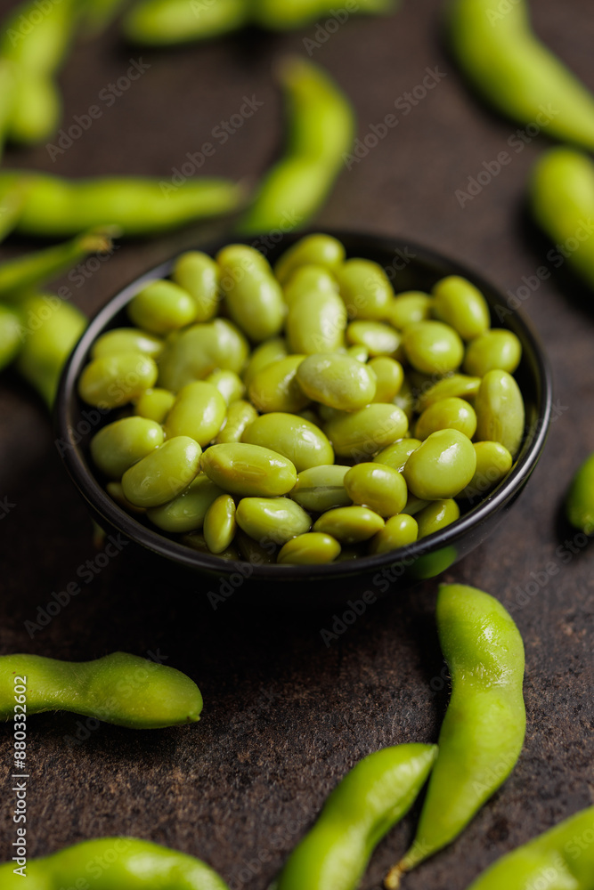 Green edamame pods. Fresh soybeans in bowl on black table. Green edamame pods. Fresh soybeans in bowl on black table.