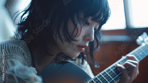 アコースティックギターを弾くアジア人女性