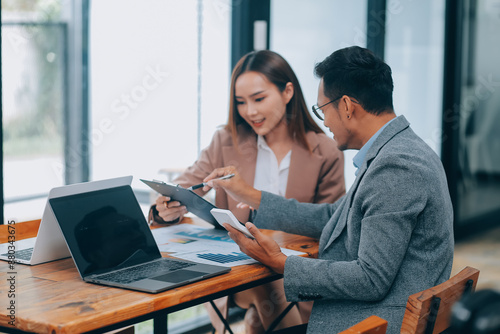 Photography group of four happy young asian corporate people teammates meeting discussing business in office
