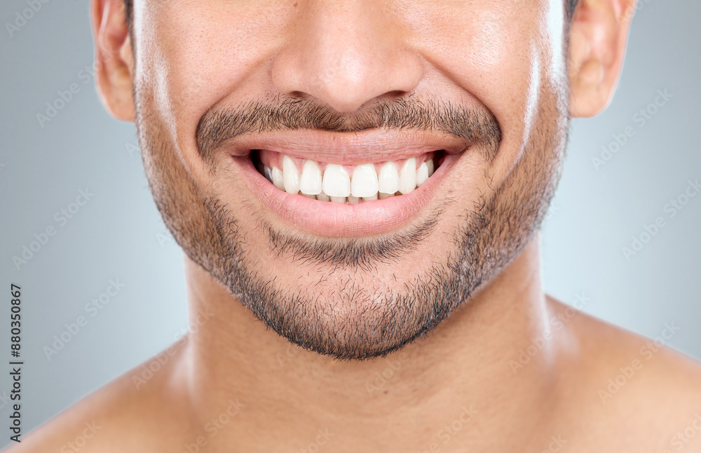 Obraz premium Man, smile and teeth whitening results in studio, orthodontics and oral health on gray background. Male person, dental hygiene and confidence for wellness, cosmetics and aesthetic of fresh breath