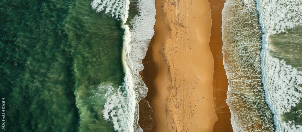 An aerial shot captures the beach split by the surf creating a diagonal division in the copy space image An aerial shot captures the beach split by the surf creating a diagonal division in the copy space image