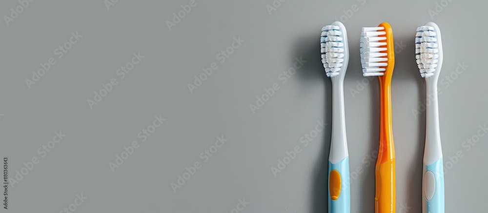 Toothbrushes both electric and plastic displayed on a grey background with copy space image Toothbrushes both electric and plastic displayed on a grey background with copy space image
