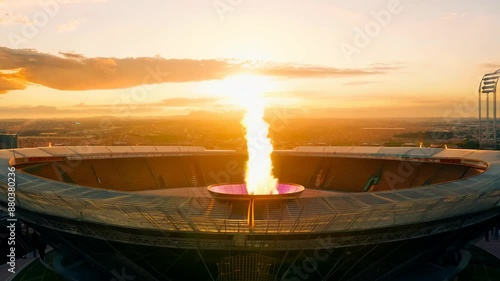 Olympic flame at sunset: dramatic slow motion footage of stadium fire ceremony at dusk