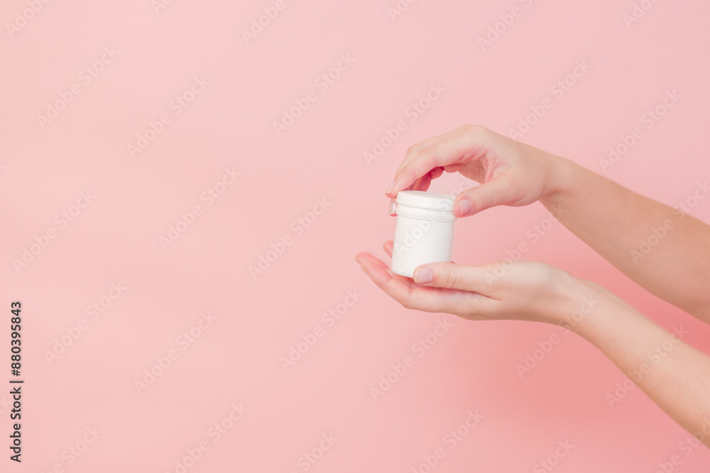 Hand with blank white plastic tube on pink background. Cosmetics beauty mockup for product branding Hand with blank white plastic tube on pink background. Cosmetics beauty mockup for product branding