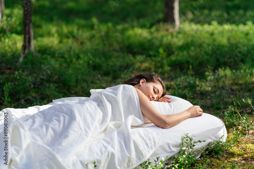 Fotografía Woman sleeps on a mattress in the summer forest