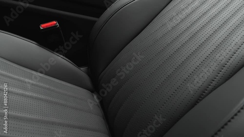 
Black leather seats with red accents in the interior of a premium car. Car interior