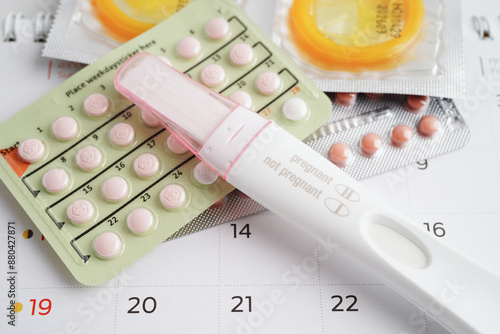 Canvastavla Pregnancy test with birth control pills and condom for female on calendar, ovulation day