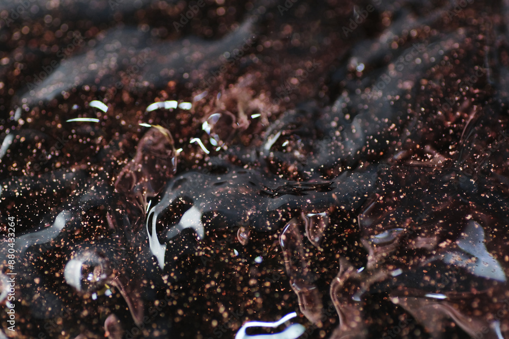 Macro shot of bronze and gold particles in water Macro shot of bronze and gold particles in water