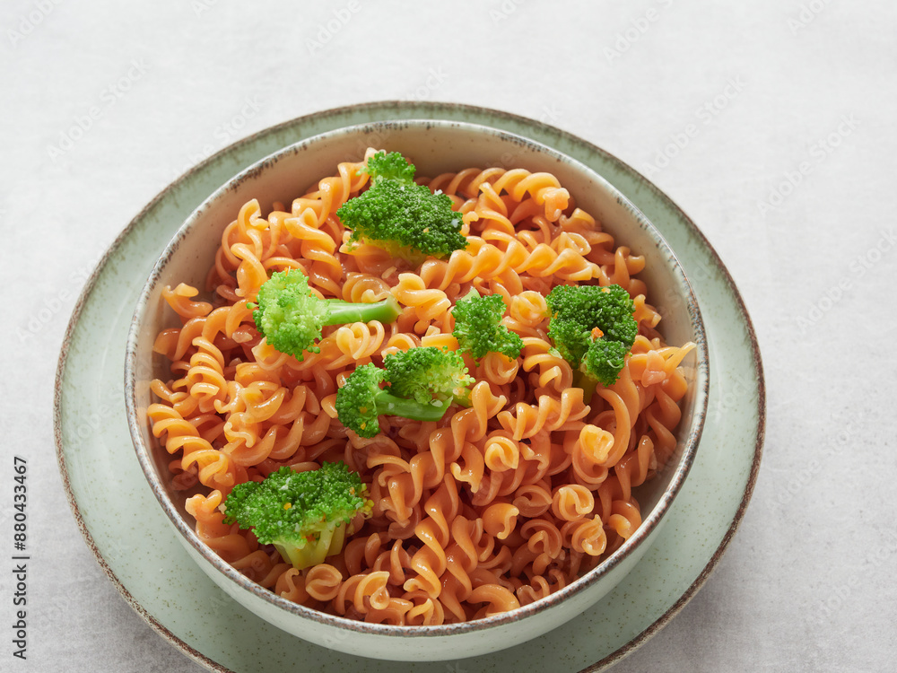 close-up of plate with red pasta spirals (fussili) and broccoli close-up of plate with red pasta spirals (fussili) and broccoli