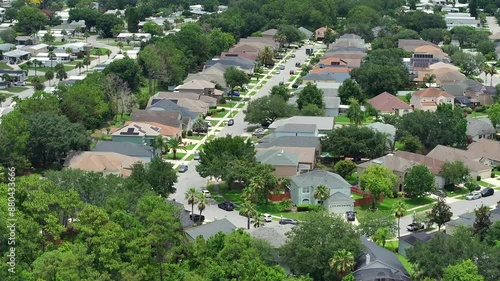 Aerial approaching shot of suburban neighborhood with single family homes of Florida, USA. Green trees in summer with modern Single family homes. Top down shot. photo