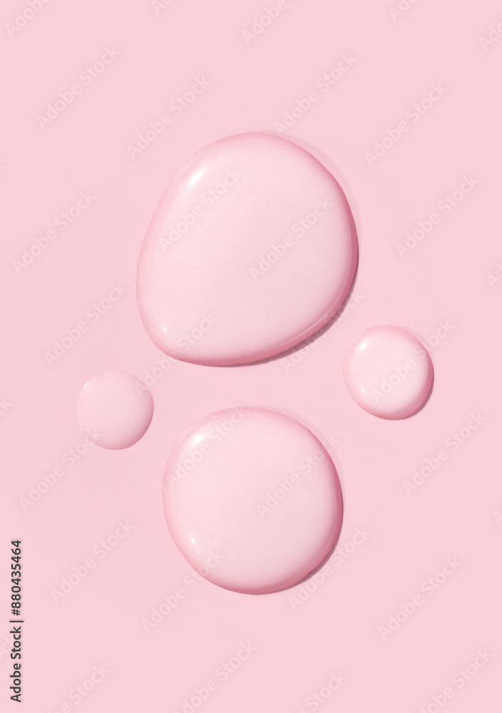 round drops of transparent gel serum on pink background round drops of transparent gel serum on pink background