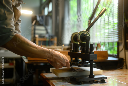 Wallpaper Mural Close up shot craftsman working with manual leather die cutting machine in his workshop Torontodigital.ca