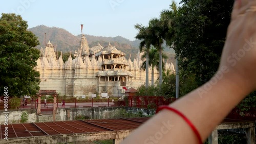 young girl praying at ancient unique temple with bright sky at day from back angle video is taken at ranakpur jain temple rajasthan india. photo