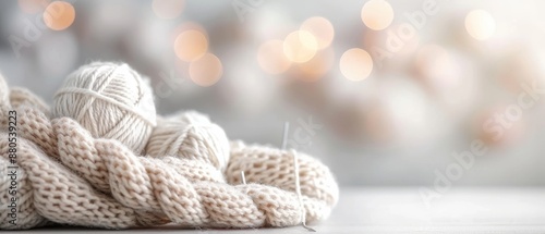 Cozy knitting concept with wool yarn and needles in soft, neutral colors. Perfect for craft, hobby, or DIY projects. Blurry festive background. photo