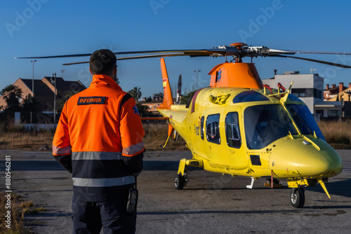 Paramedic looking at the medical helicopter that is landed at the airfield.