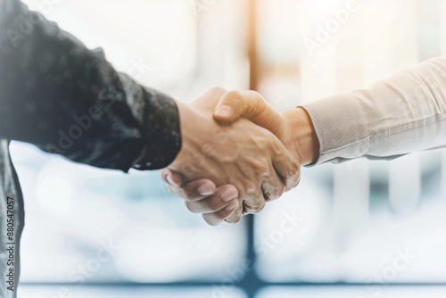 Close up of business people shaking hands in office, white blurred background with copy space concept for successful deal and collaboration in corporate company.