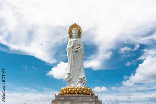 SANYA, HAINAN, CHINA Buddhist deity statue Guainin with a tourist plane in the sky