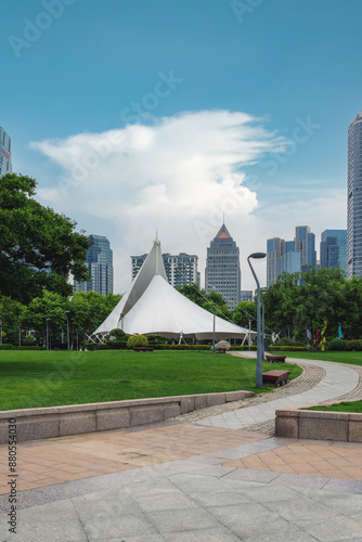 Modern Urban Park with White Tent and City Skyline