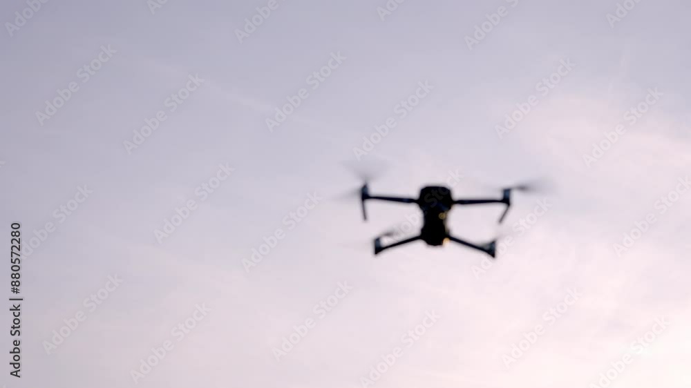 close-up of a drone in flight against a clear sky, highlighting its propellers and camera. close-up of a drone in flight against a clear sky, highlighting its propellers and camera.