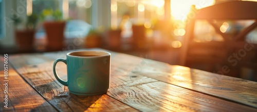 Fototapeta Naklejka Na Ścianę i Meble -  An office at sunrise with a wooden table holding a coffee cup has a cozy and inviting ambiance perfect for a copy space image