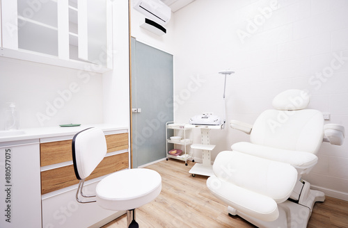 Light interior of modern aesthetic cosmetolody clinic with chair for patient and equipment for cosmetic procedures