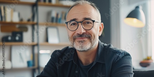 A person sitting at a desk looking over notes and wearing glasses