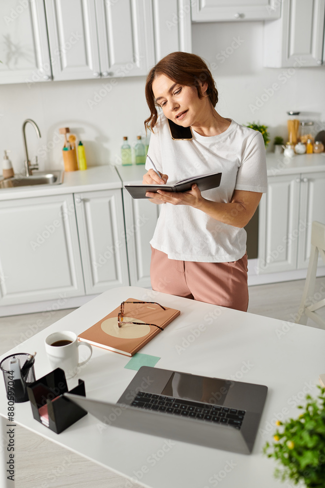 Middle aged woman standing in a kitchen holding a book. Middle aged woman standing in a kitchen holding a book.