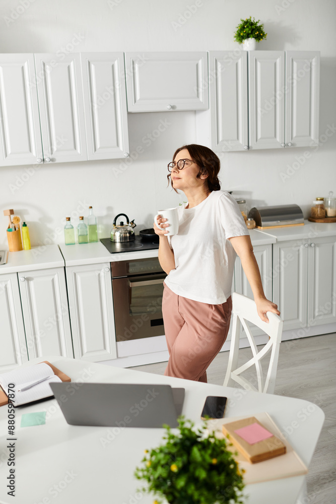 Middle-aged lady standing by table in kitchen. Middle-aged lady standing by table in kitchen.