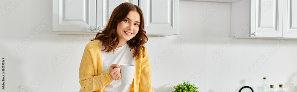 Middle-aged woman in yellow cardigan standing gracefully in kitchen. Middle-aged woman in yellow cardigan standing gracefully in kitchen.