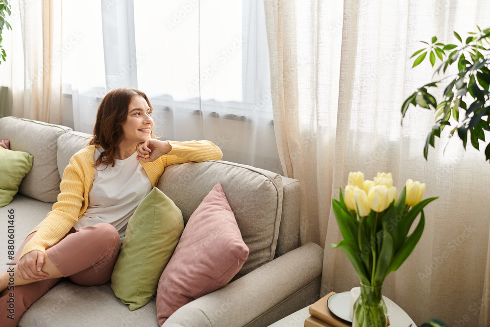 Middle-aged woman sitting comfortably on a couch in a cozy living room. Middle-aged woman sitting comfortably on a couch in a cozy living room.