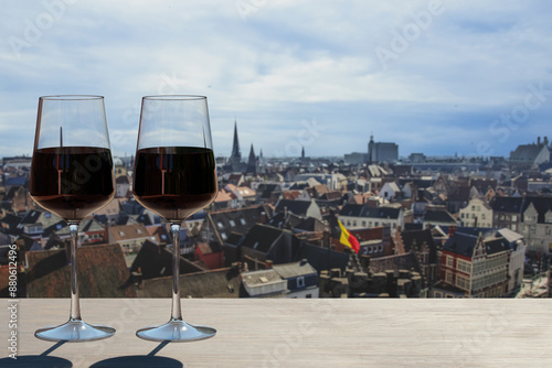 Two glasses of red wine with panoramic view from above of vibrant city center of Brussels, Belgium.