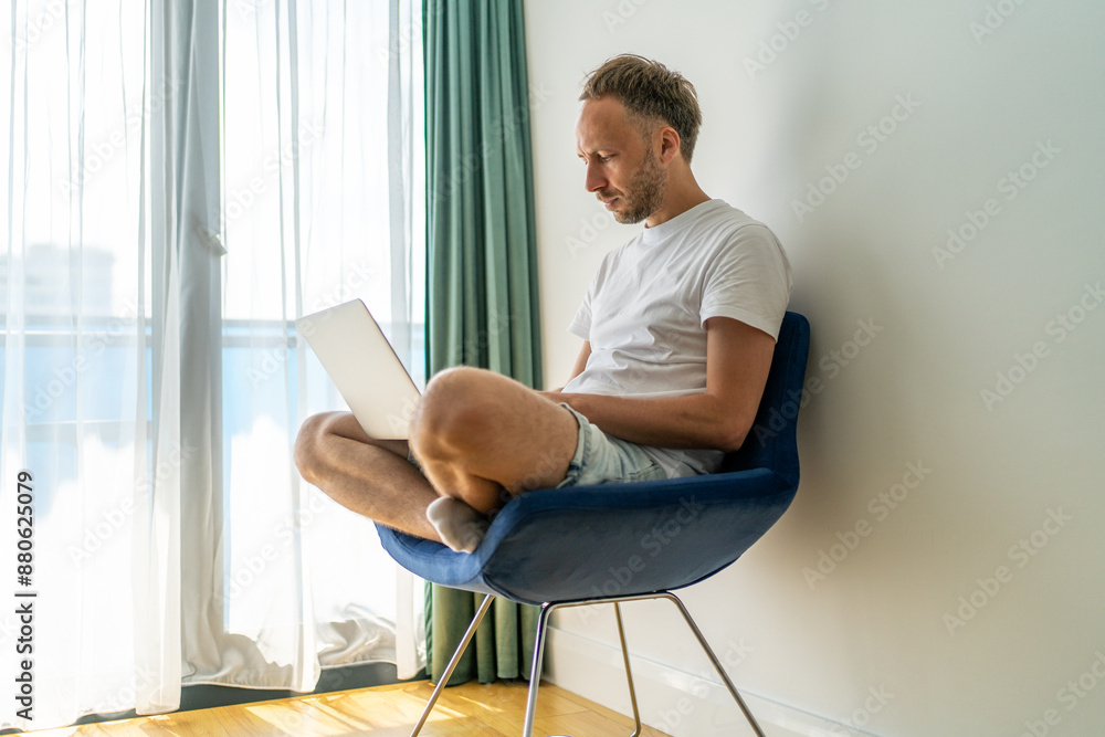 Man Working on Laptop in Bright Room. Man Working on Laptop in Bright Room.