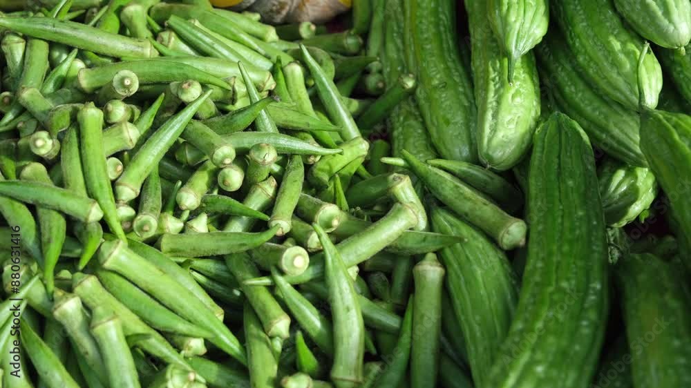 Display of fresh, new young edible lady fingers and bitter gourd vegetables at the market in 4K video Display of fresh, new young edible lady fingers and bitter gourd vegetables at the market in 4K video
