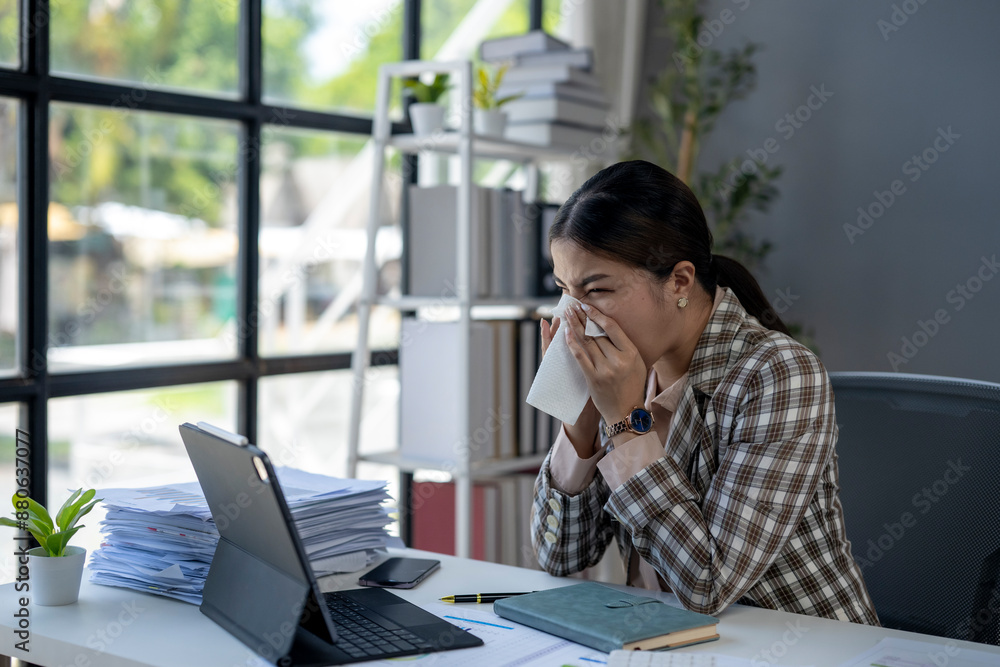 A woman is sitting at a desk with a computer and a stack of papers A woman is sitting at a desk with a computer and a stack of papers