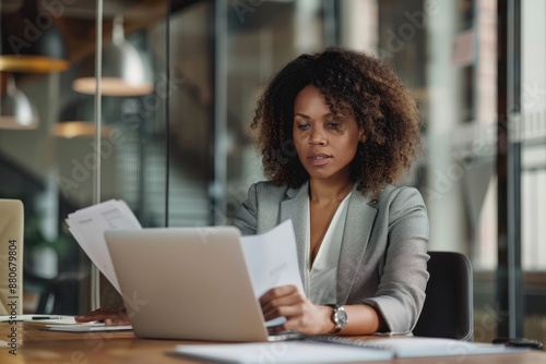 Portrait of businesswoman with laptop writes on a notebook at her office