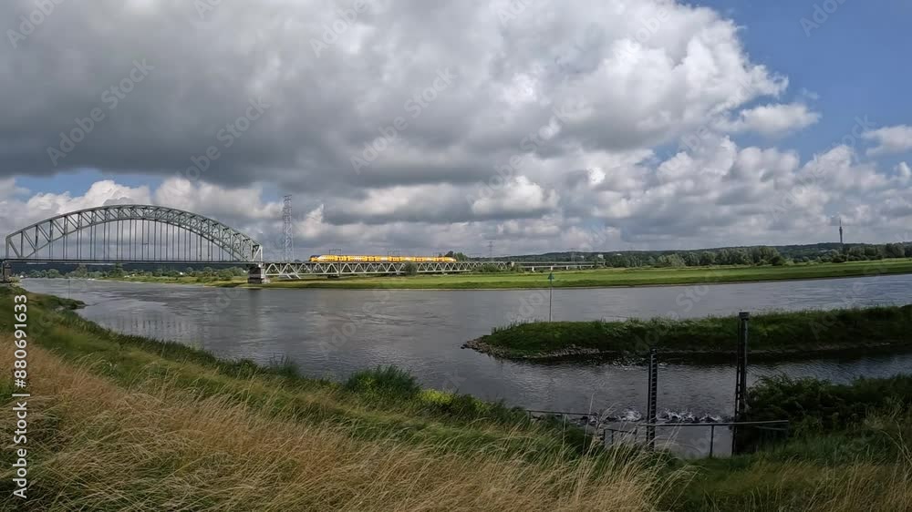 Dutch passenger train drives over the railway bridge over the Rhine near Arnhem in July 2024 Dutch passenger train drives over the railway bridge over the Rhine near Arnhem in July 2024