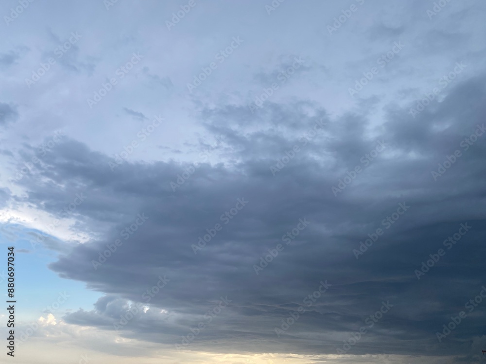 Blue, cloudy, moody sky. The sun is breaking through the cloud Blue, cloudy, moody sky. The sun is breaking through the cloud