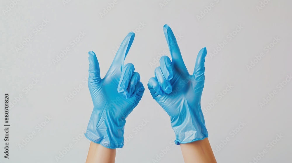 Woman s hands in blue gloves pointing upward against white background Woman s hands in blue gloves pointing upward against white background
