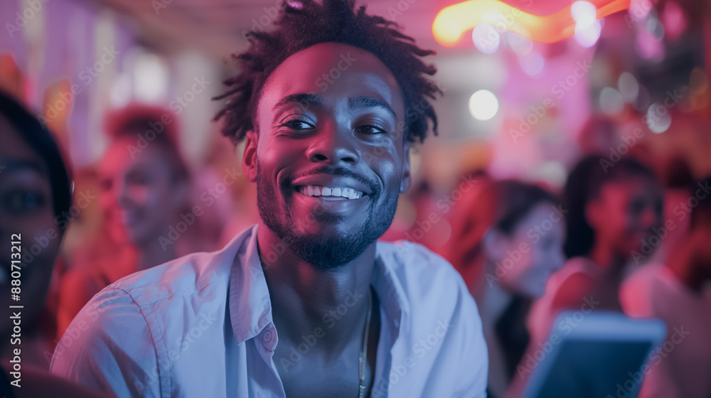 A man with a big smile is standing in a crowd of people. He is wearing a white shirt and a gold necklace. Scene is happy and lively A man with a big smile is standing in a crowd of people. He is wearing a white shirt and a gold necklace. Scene is happy and lively