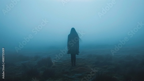 Solitary person engulfed by darkness radiating a sense of utter despair with barely perceptible light in the distance enhancing the feeling of isolation and helplessness