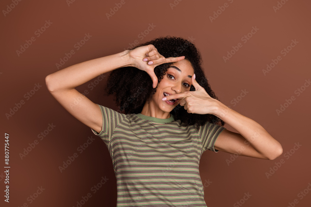 Photo of adorable lovely girl wear khaki t-shirt showing arms photo empty space isolated brown color background Photo of adorable lovely girl wear khaki t-shirt showing arms photo empty space isolated brown color background