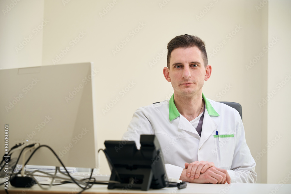Fototapeta premium Physician posing for camera in his office