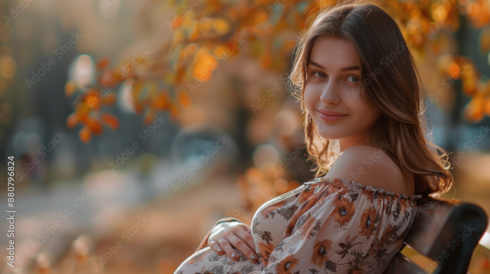 Young pregnant woman in a dress sits on a bench in an autumn sunny park Young pregnant woman in a dress sits on a bench in an autumn sunny park