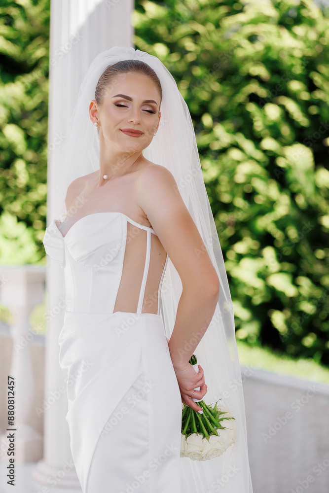 A woman in a white dress is holding a bouquet of flowers. She is smiling and looking at the camera. Concept of happiness and celebration, as the woman is likely attending a wedding or a special event A woman in a white dress is holding a bouquet of flowers. She is smiling and looking at the camera. Concept of happiness and celebration, as the woman is likely attending a wedding or a special event