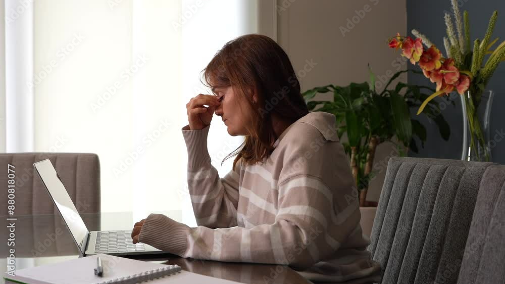 Mujer trabajando en la computadora, estresada y 
cansada