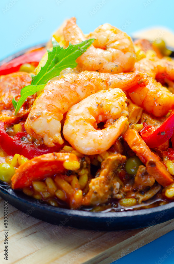 A black pan filled with a variety of food including shrimp, peppers, and corn A black pan filled with a variety of food including shrimp, peppers, and corn