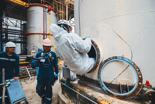 Male worker into the tank carbon chemical oil interface area confined photo