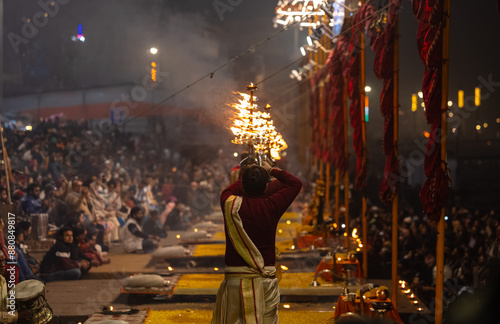 Ganga aarti, Portrait of young priest performing holy river ganges evening aarti at assi ghat in traditional dress with hindu rituals at dashashwamedh ghat.