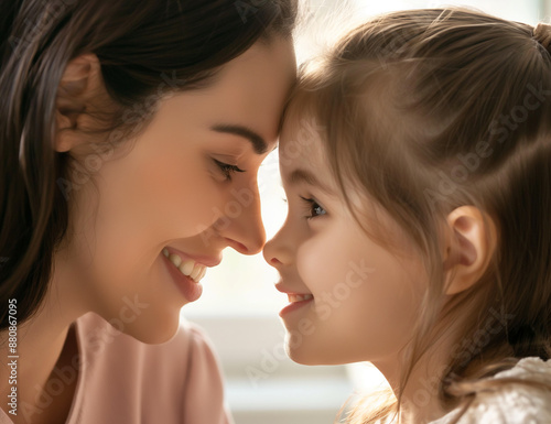 Close up de perfil lateral enfrenta a visão de uma jovem mãe amorosa de 30 anos e uma linda filha pré-escolar sorrindo, olhando uma para a outra com ternura e amor. Maternidade feliz, infância despre